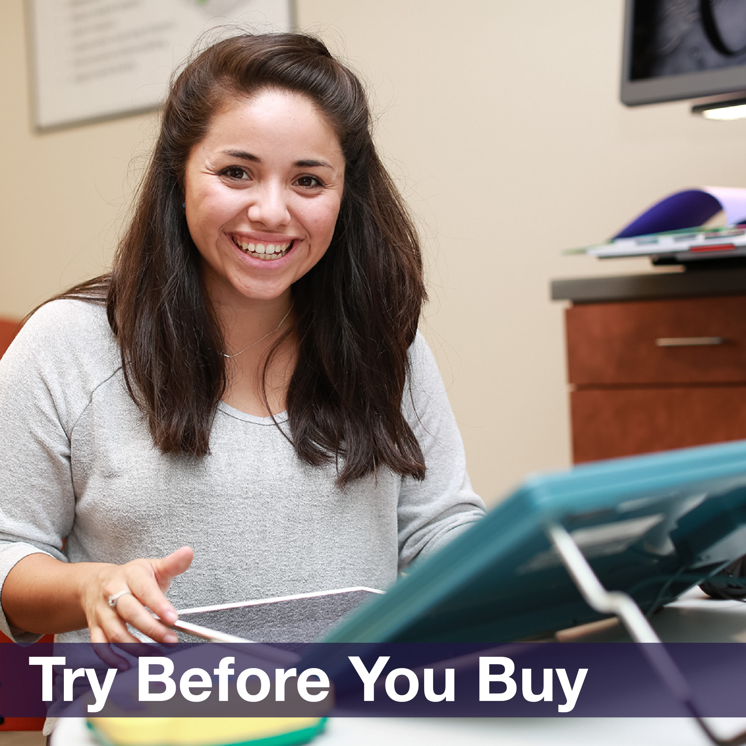 A young woman smiling and using a tablet, accompanied by the phrase “Try before you buy”